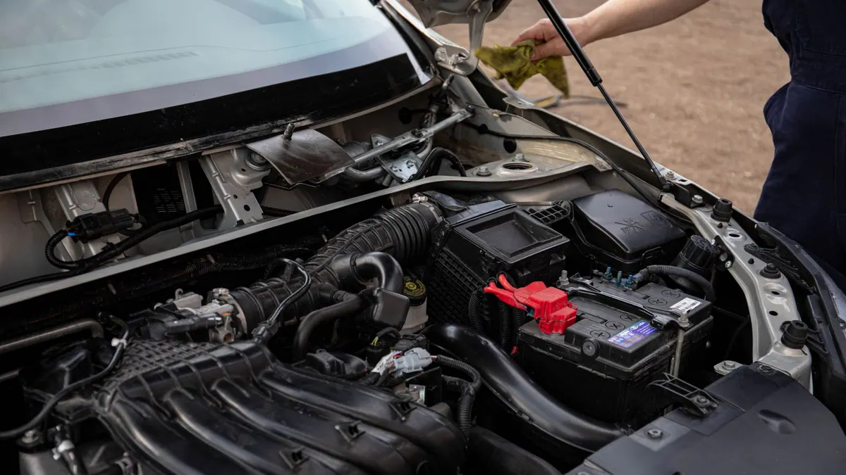 Mécanicien inspectant le compartiment moteur et la batterie
